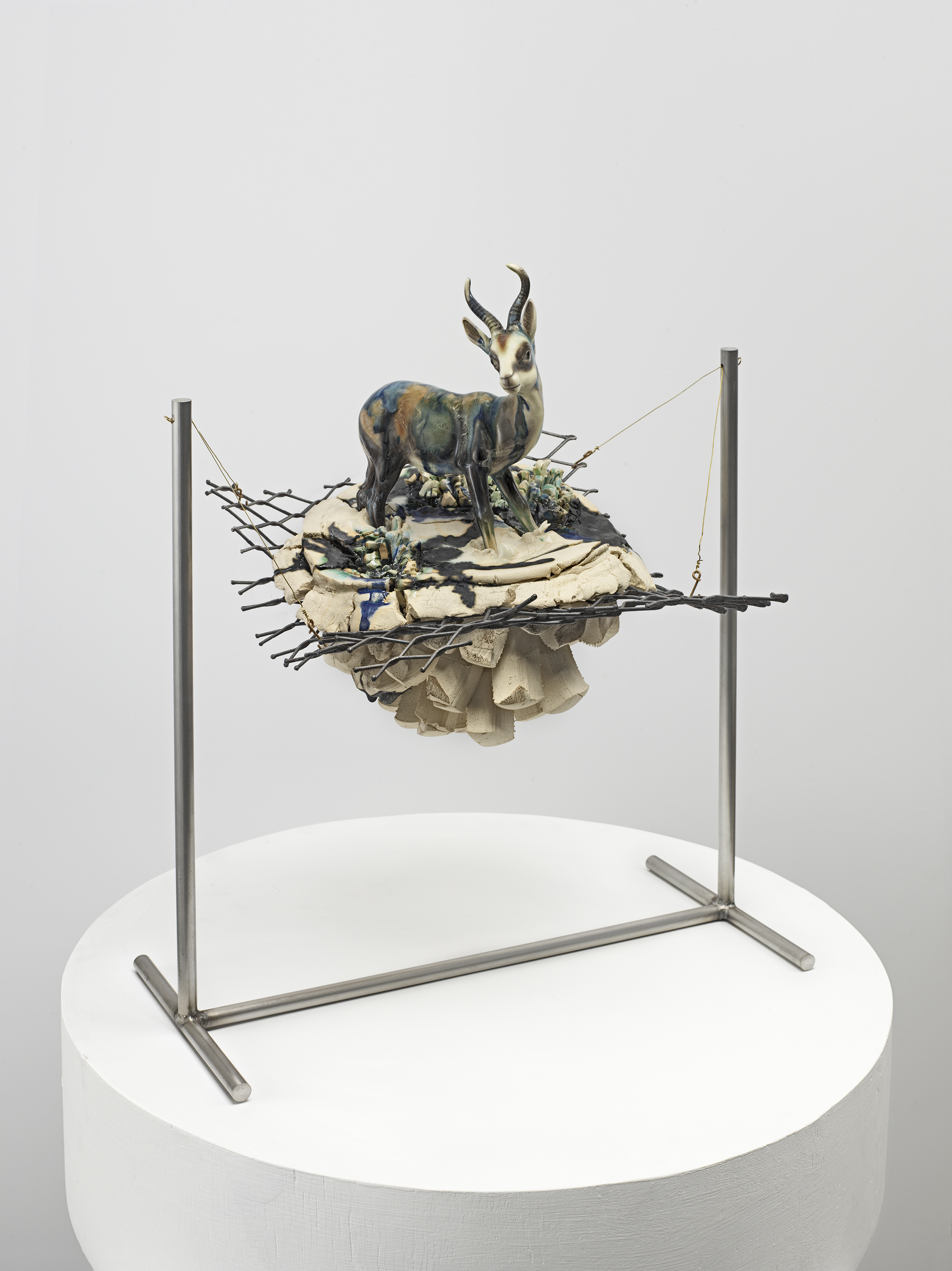 Jon Kessler, Stranded, 2024, Stainless steel, brass, glazed stoneware ad porcelain figurine
20 x 17 x 12 1/2 in.