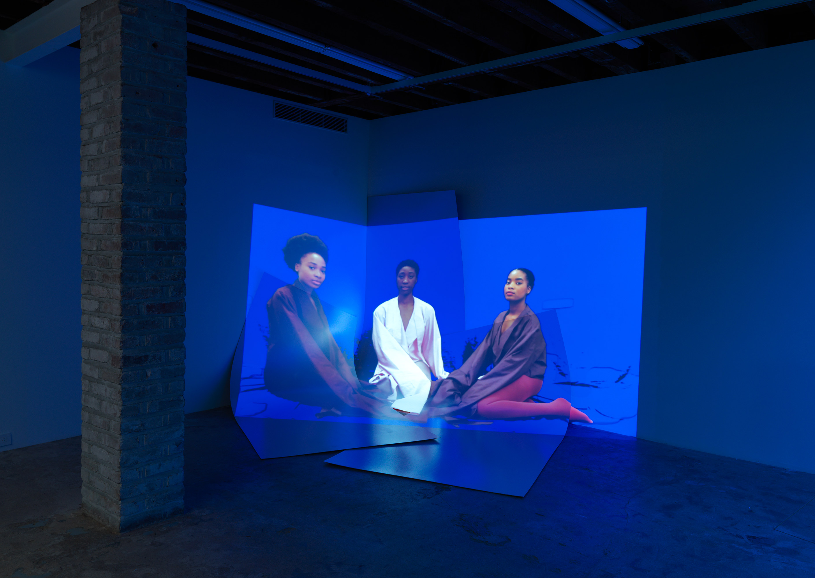 Sandra Mujinga, Catching Up, 2017, HD video projection loop with sound, 10:16 minutes, MDF panels, paint, dimensions variable