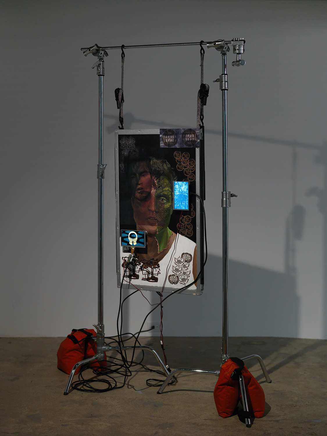 Theodore Darst, And How To Find The Real One, 2017, acrylic on Panasonic HD Monitor, Vinyl Sticker, 3 HD Video Loops, C Stand, Sandbags, dimensions variable